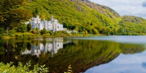 Grand house on lake with mountain behind