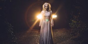 Woman with silver hair standing in darkness