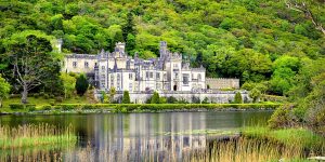 The abbey sitting across a lake surrounded by greenery