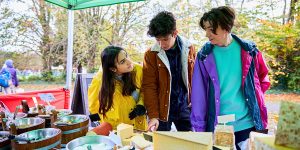 Three young people at the cheese stall