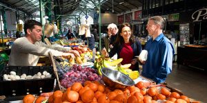 Couple buying fruit from a market vendor