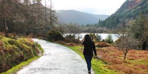 Woman walking alongside lake