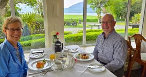 Couple having breakfast with scenic lake views in the background